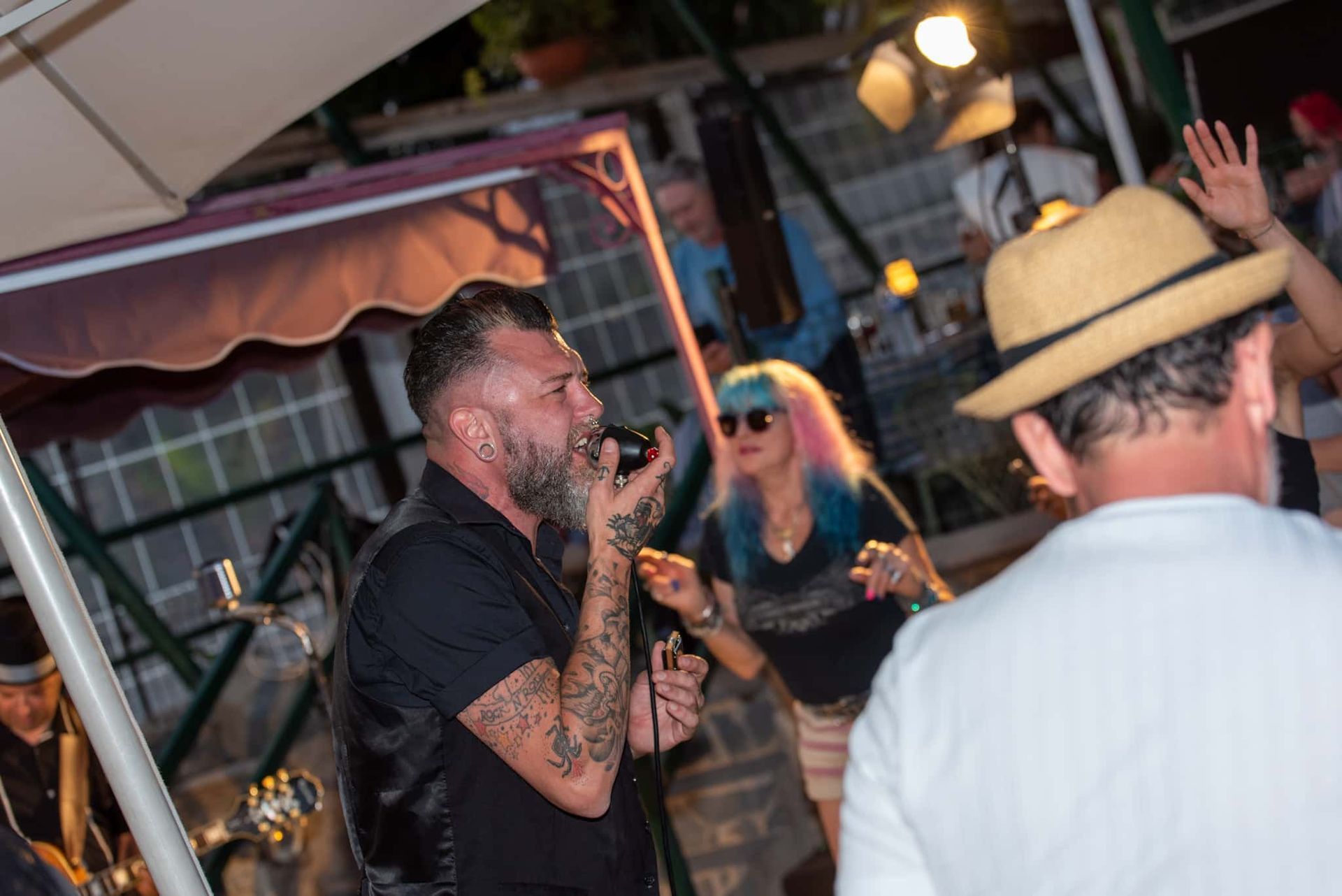 A man is singing into a microphone in front of a crowd of people.
