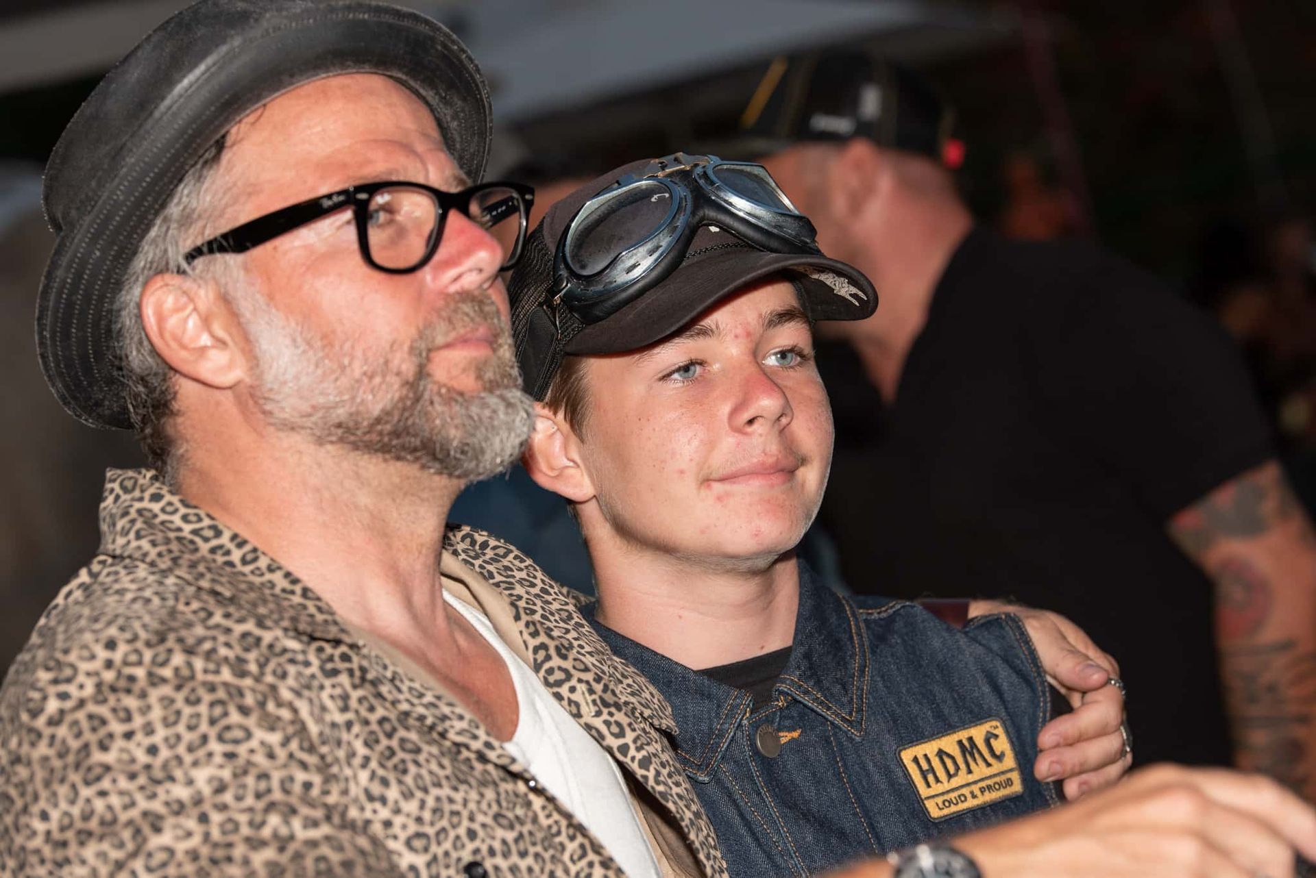 A man and a boy wearing goggles are sitting next to each other.