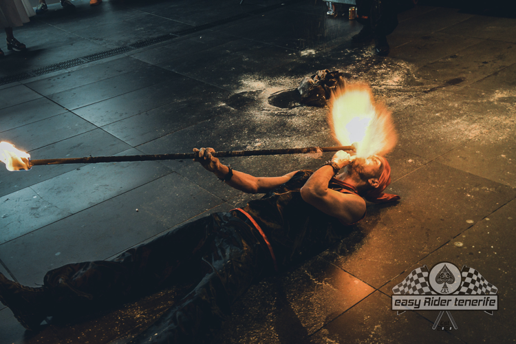 A man is laying on the ground with a torch in his mouth ..