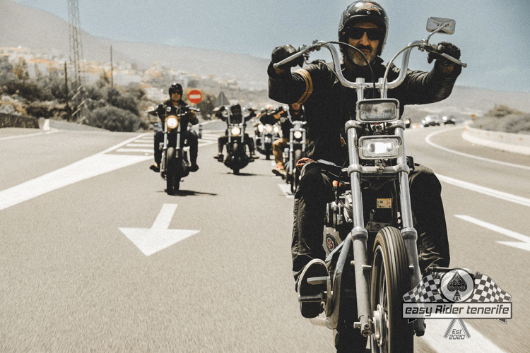 A group of people are riding motorcycles down a road