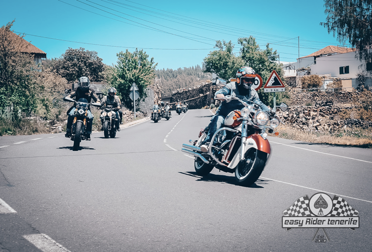 A group of people are riding motorcycles down a road.