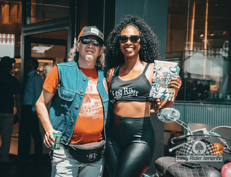 A man and a woman are posing for a picture next to a motorcycle.