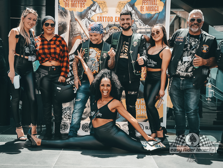 A group of people are posing for a picture in front of a sign.