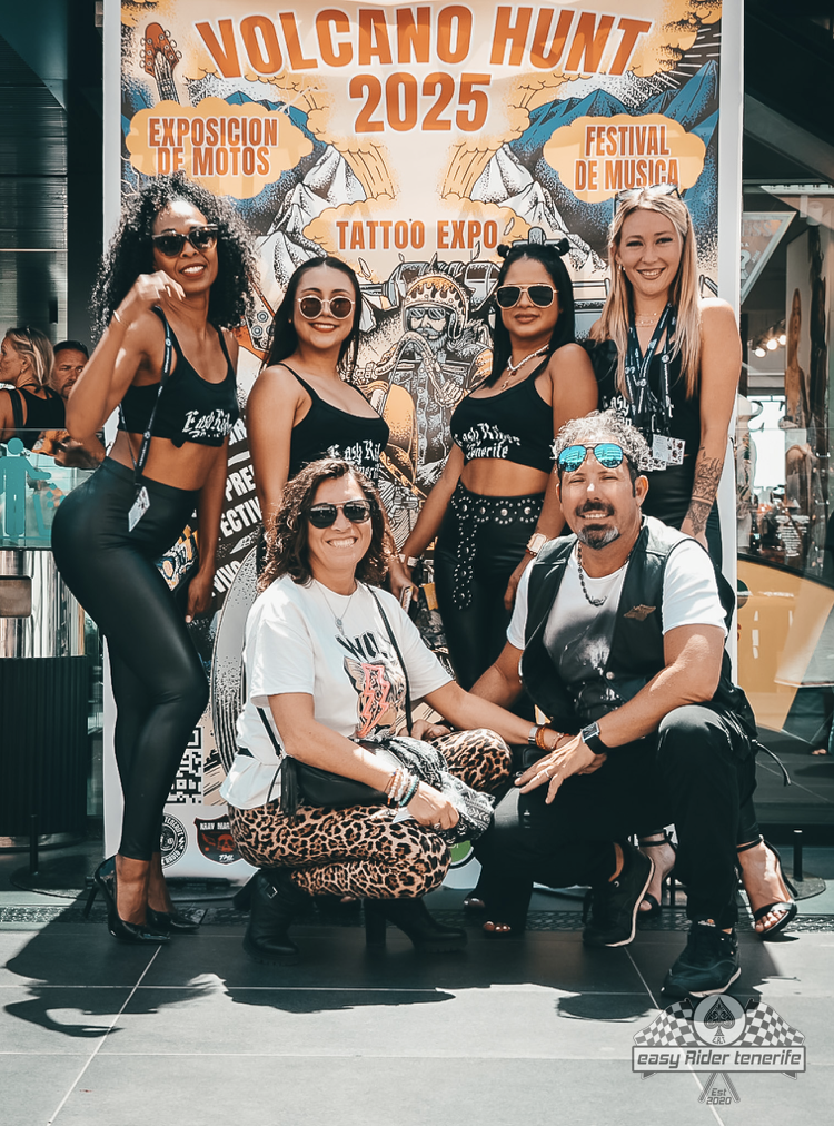 A group of people posing for a picture in front of a sign that says a volcano hunt 2025