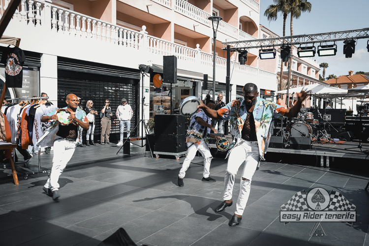 A group of men are dancing on a stage in front of a crowd.