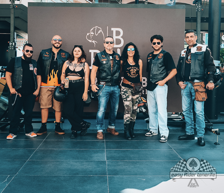 A group of people standing in front of a wall with the letter b on it
