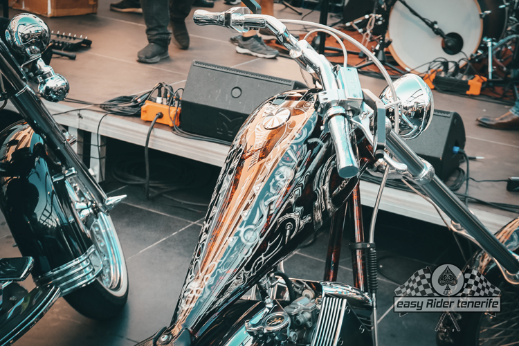 A motorcycle is parked on a stage in front of a drum set.