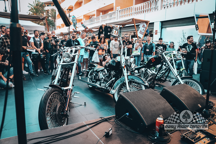 A group of people are standing around motorcycles on a stage.