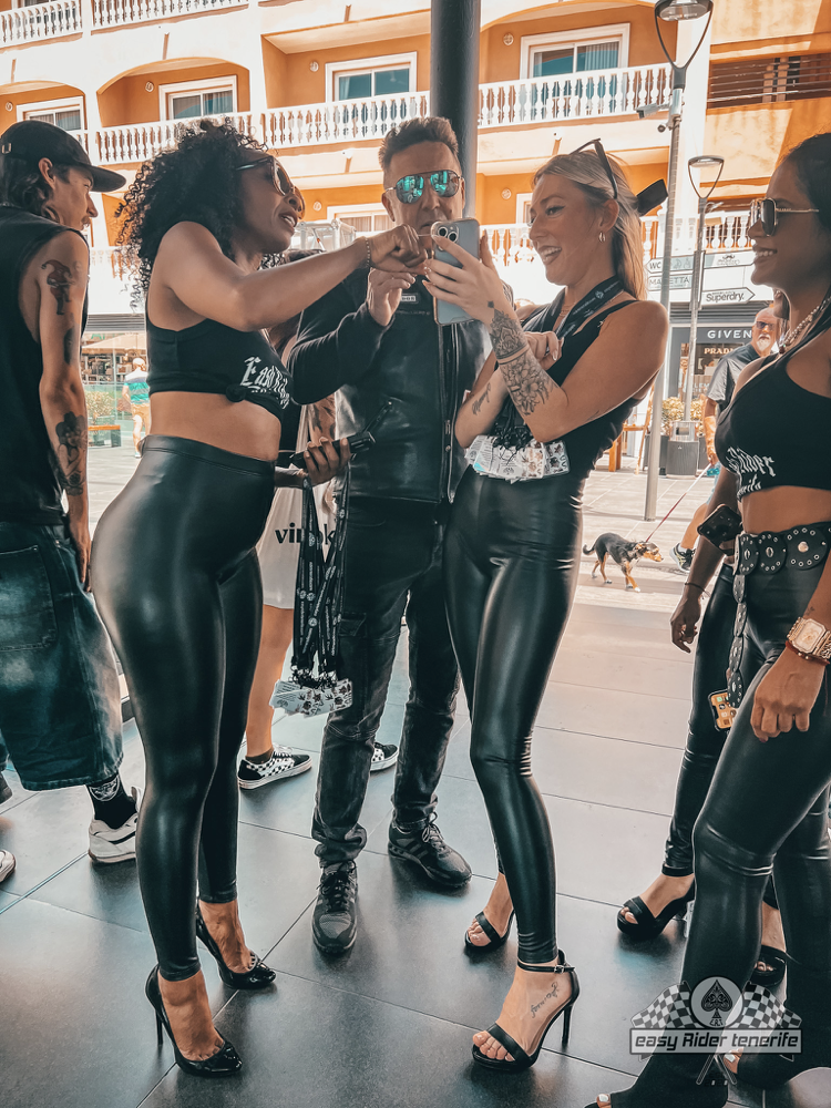 A group of people standing next to each other taking a selfie.
