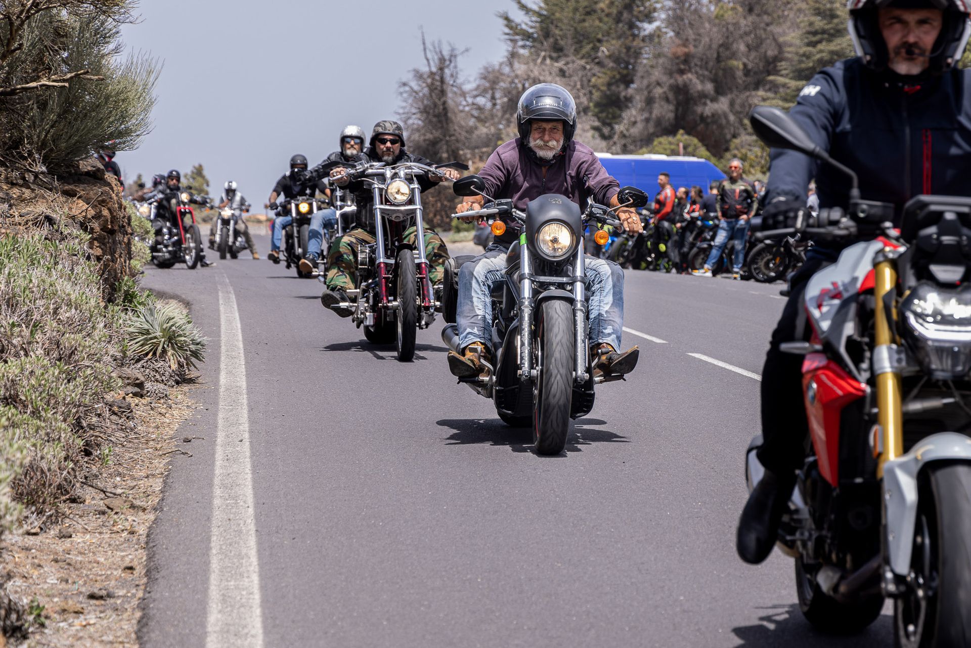 A group of people are riding motorcycles down a road