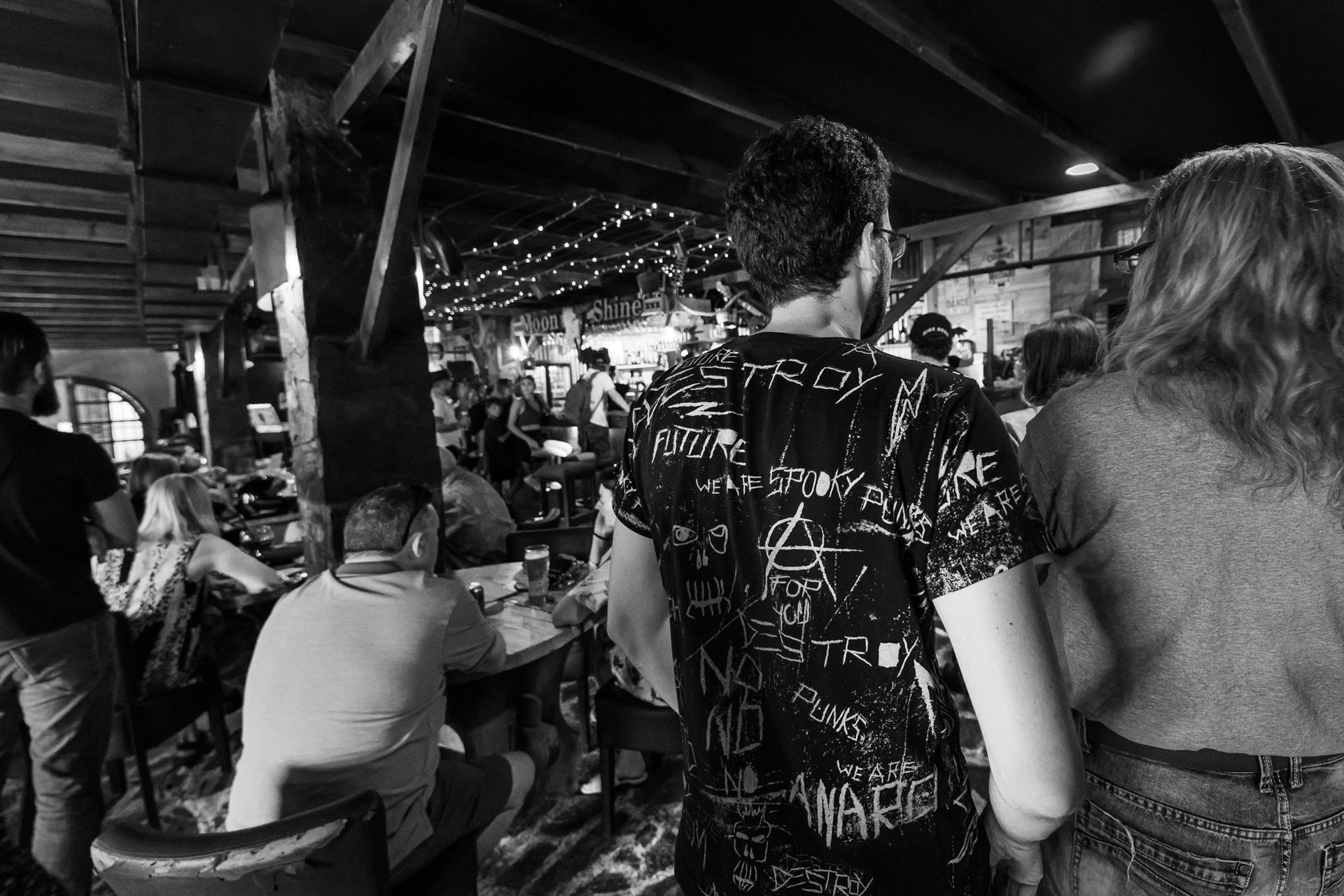 A black and white photo of people standing in a restaurant.