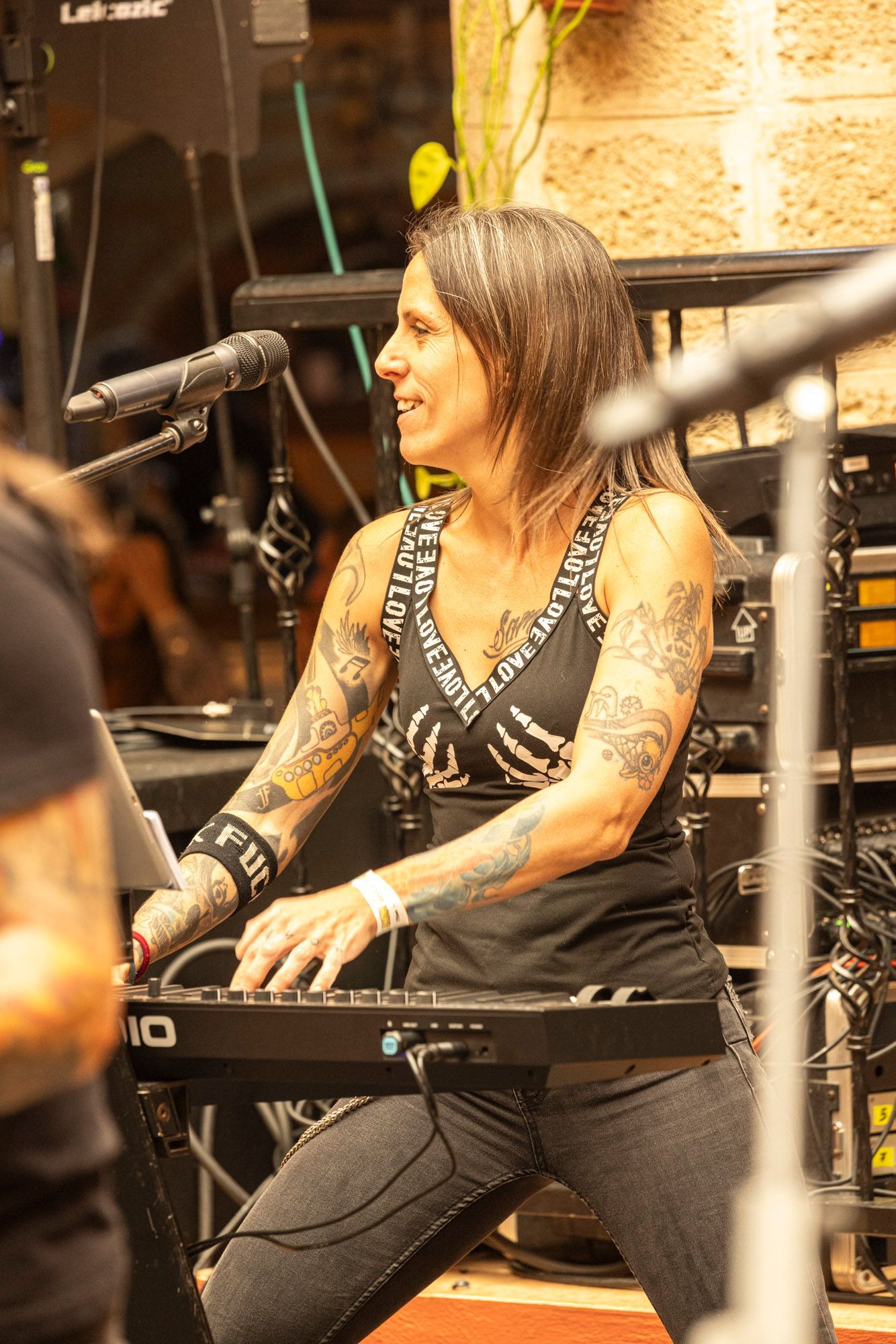 A woman is playing a keyboard in front of a microphone.