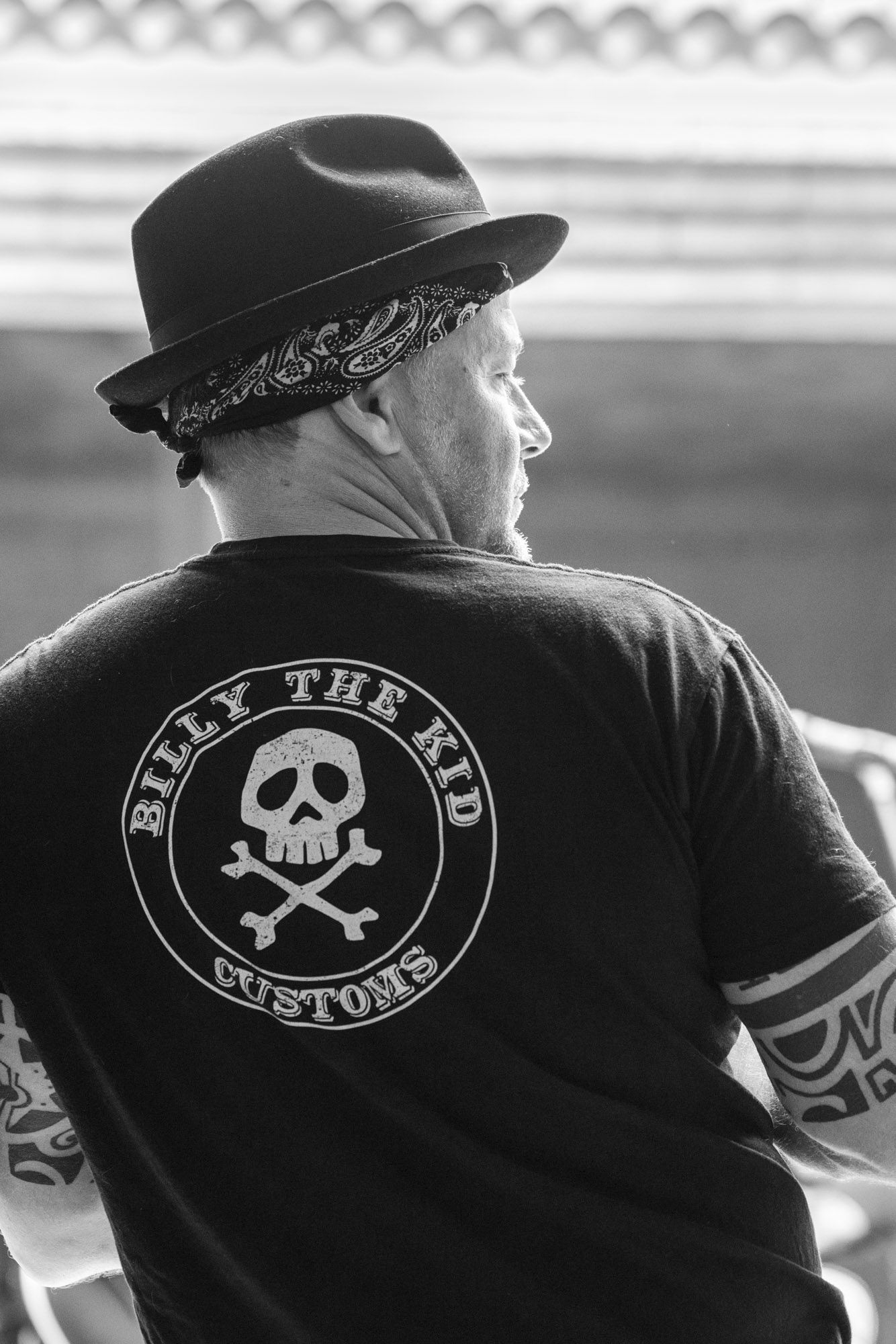 A man wearing a black shirt with a skull and crossbones on it