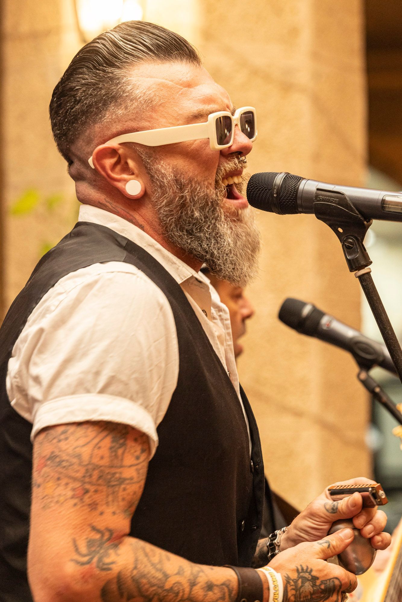 A man with a beard is singing into a microphone.