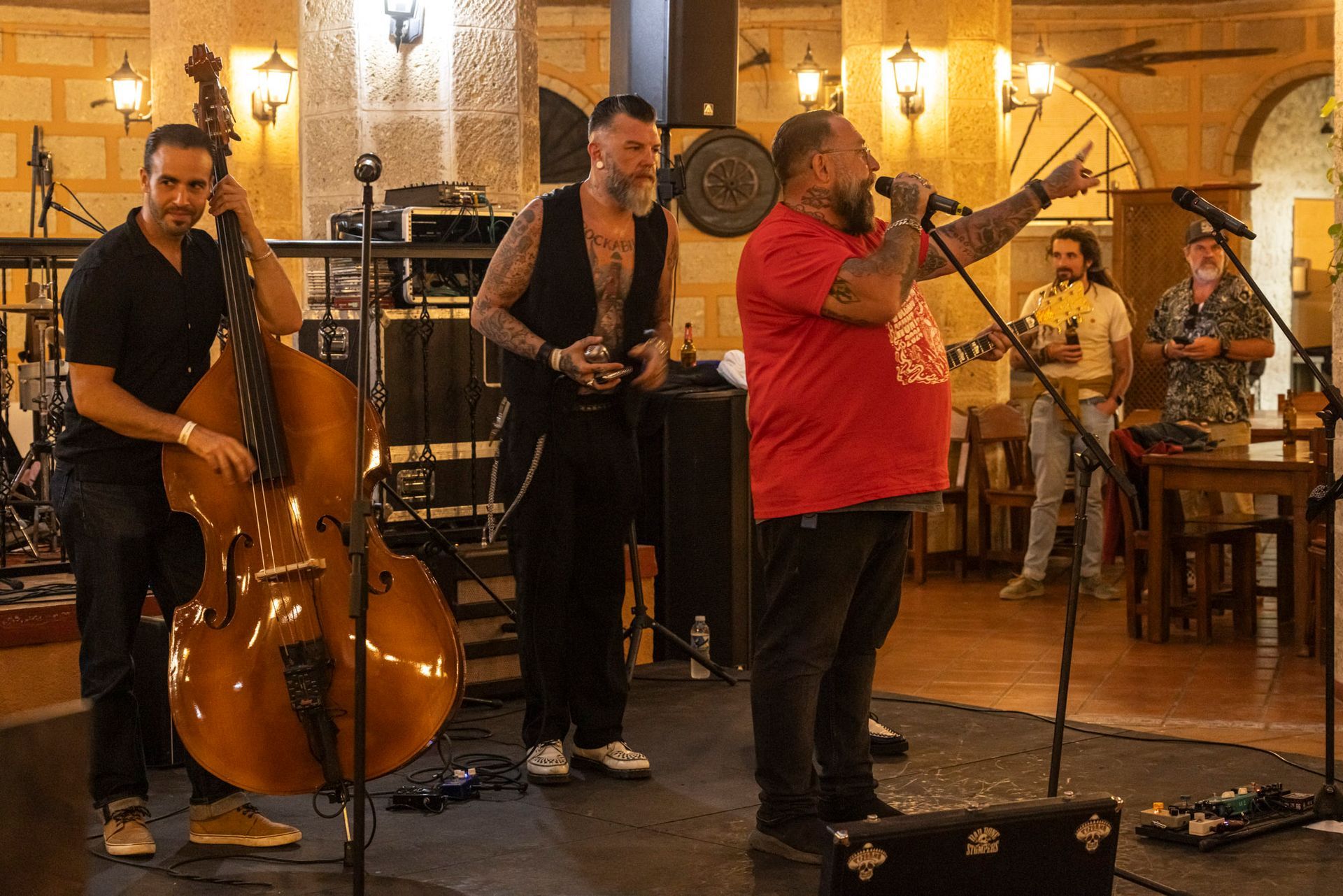 A group of men are playing instruments and singing into microphones on a stage.