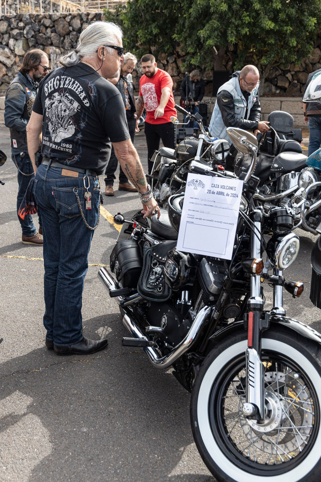 A group of men are standing around a row of motorcycles.