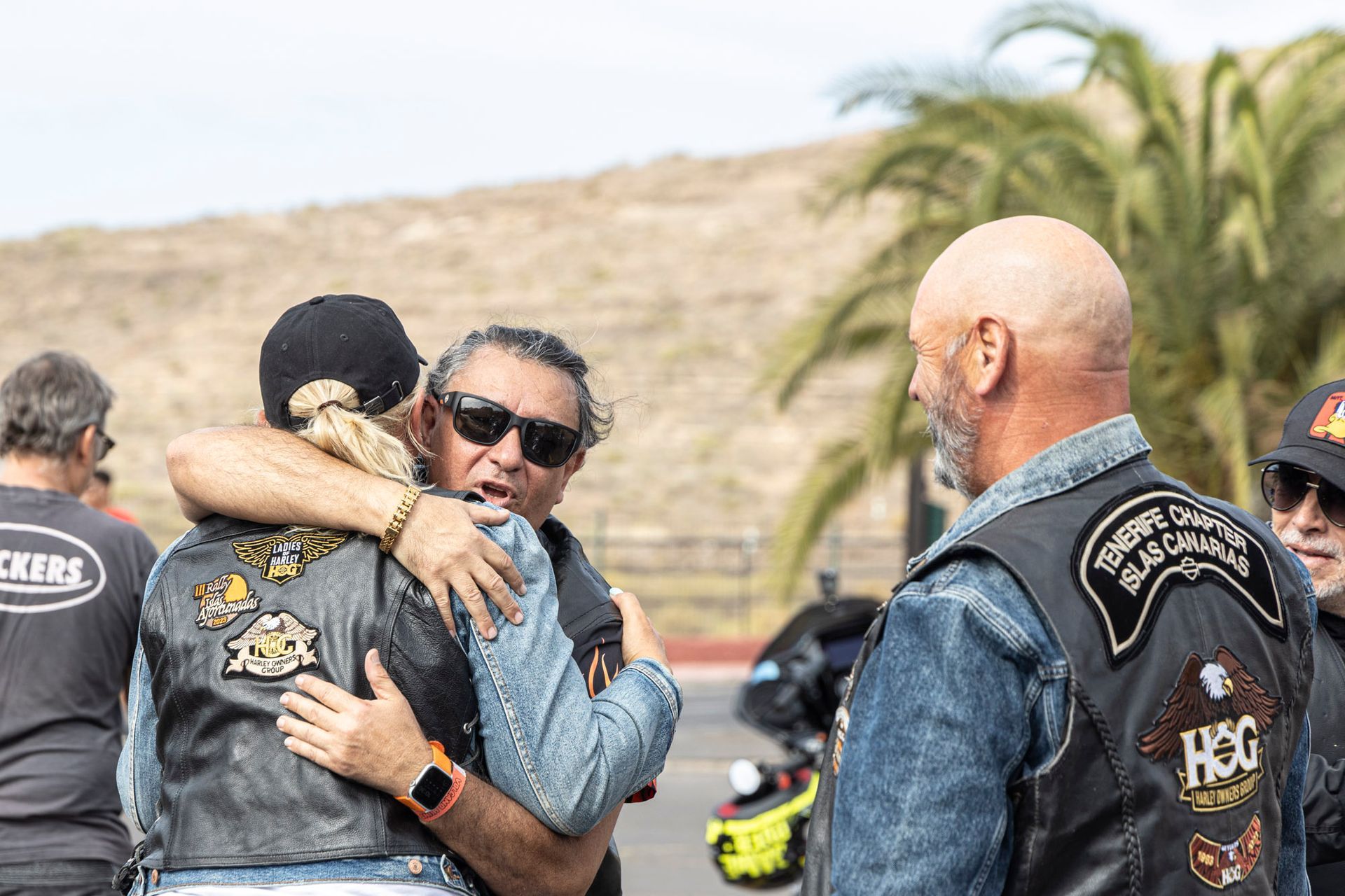 A group of men are hugging each other on a road.