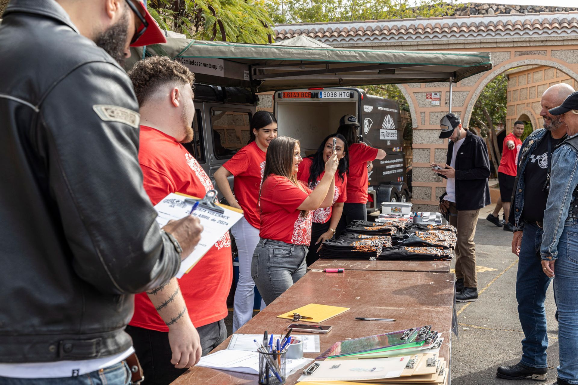 A group of people are standing around a table.