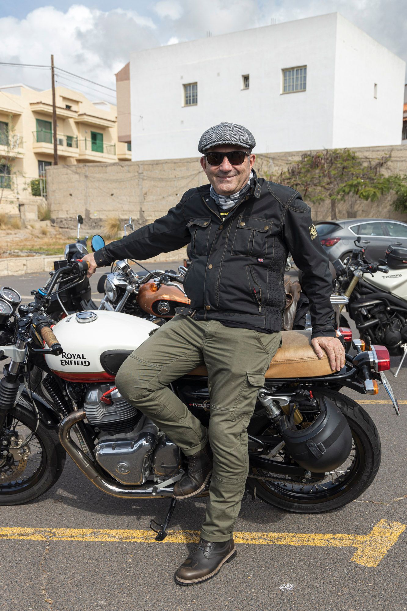 A man is sitting on a motorcycle in a parking lot.