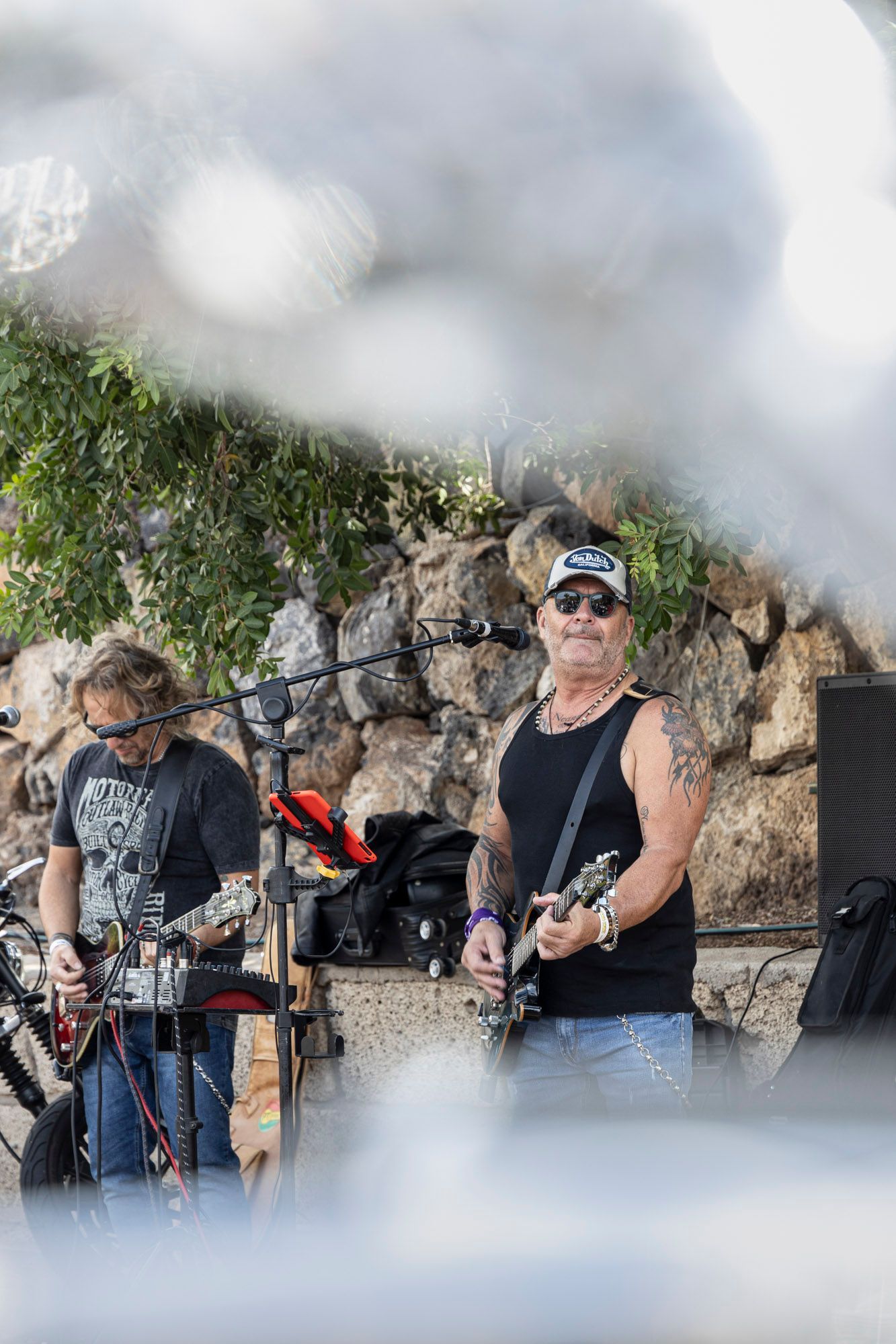 A man is playing a guitar and a man is playing a keyboard.