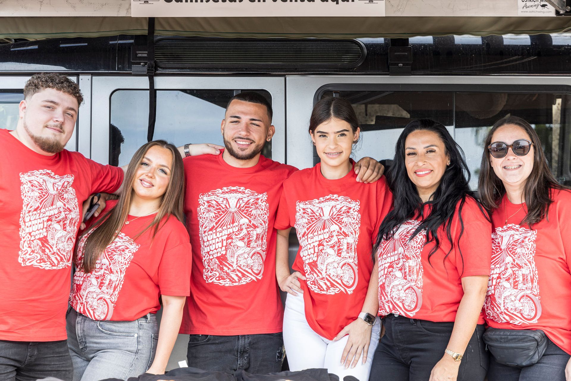 A group of people wearing red shirts are posing for a picture.