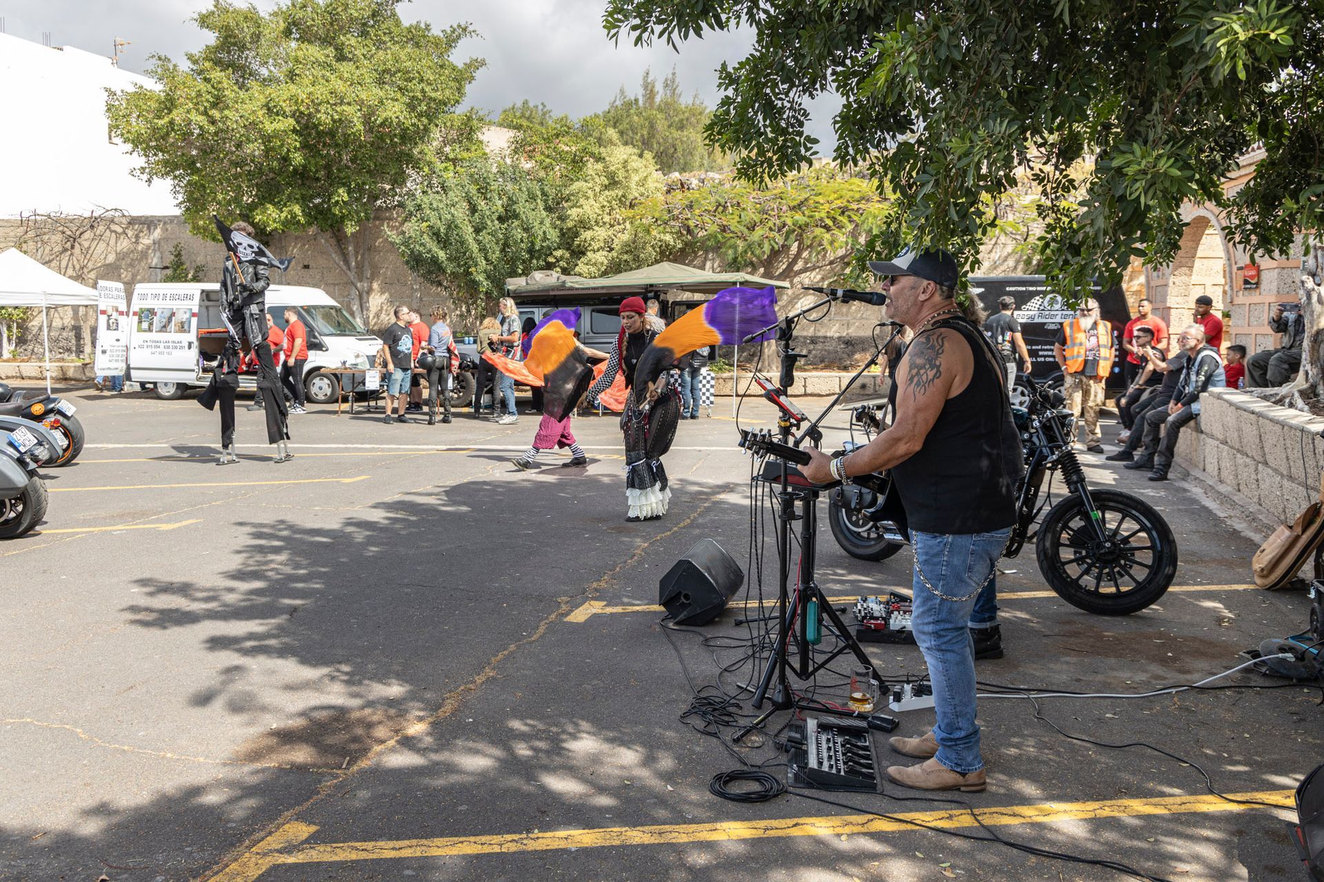 A man is singing into a microphone while standing next to a motorcycle.