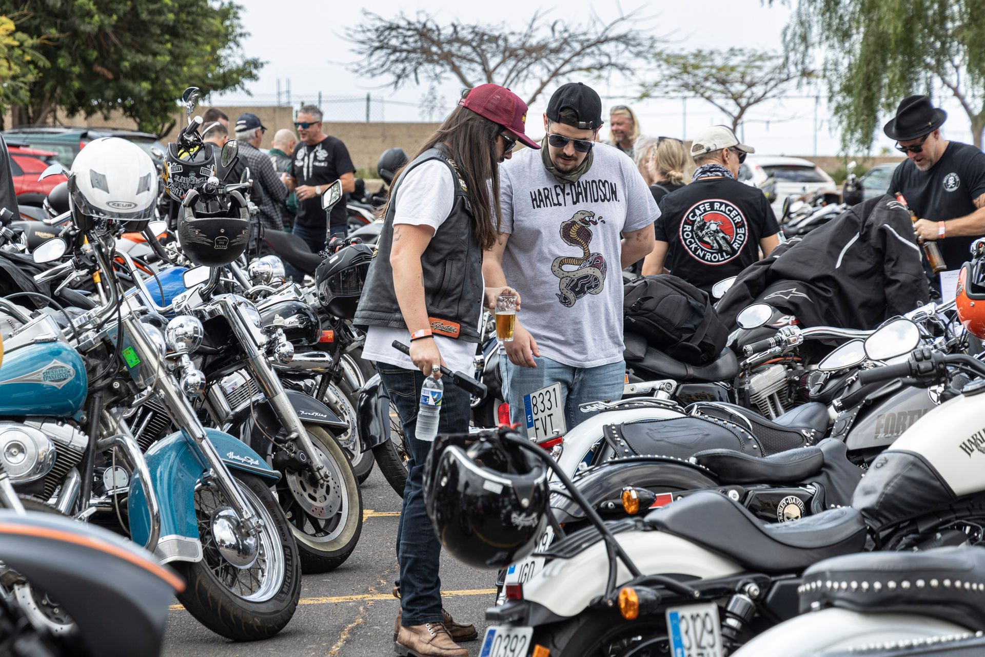 A man and a woman are standing in front of a row of motorcycles.
