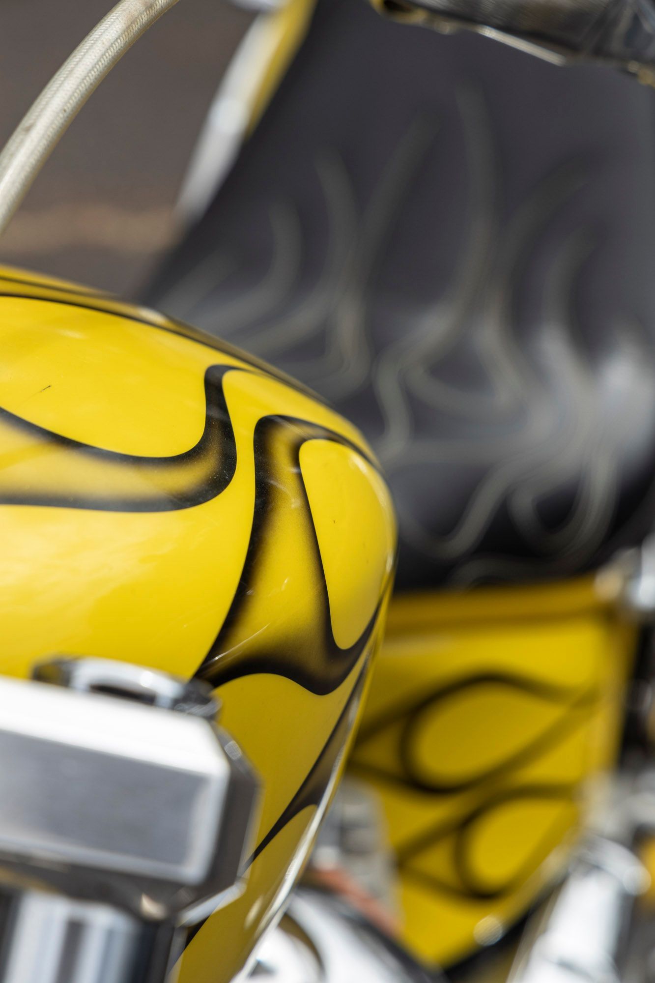 A close up of a yellow motorcycle with flames painted on it