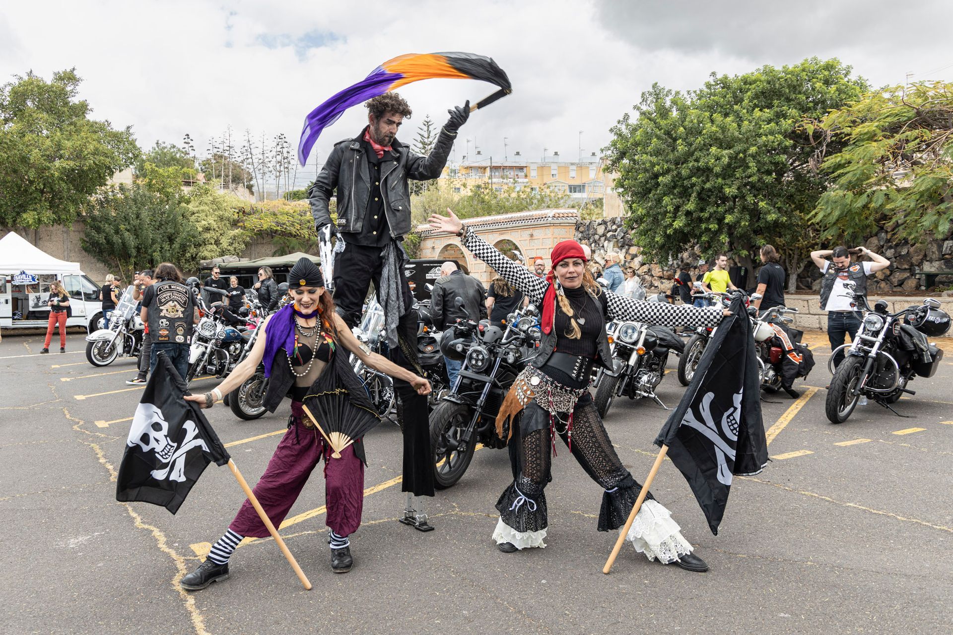 A group of people dressed as pirates are standing next to motorcycles.