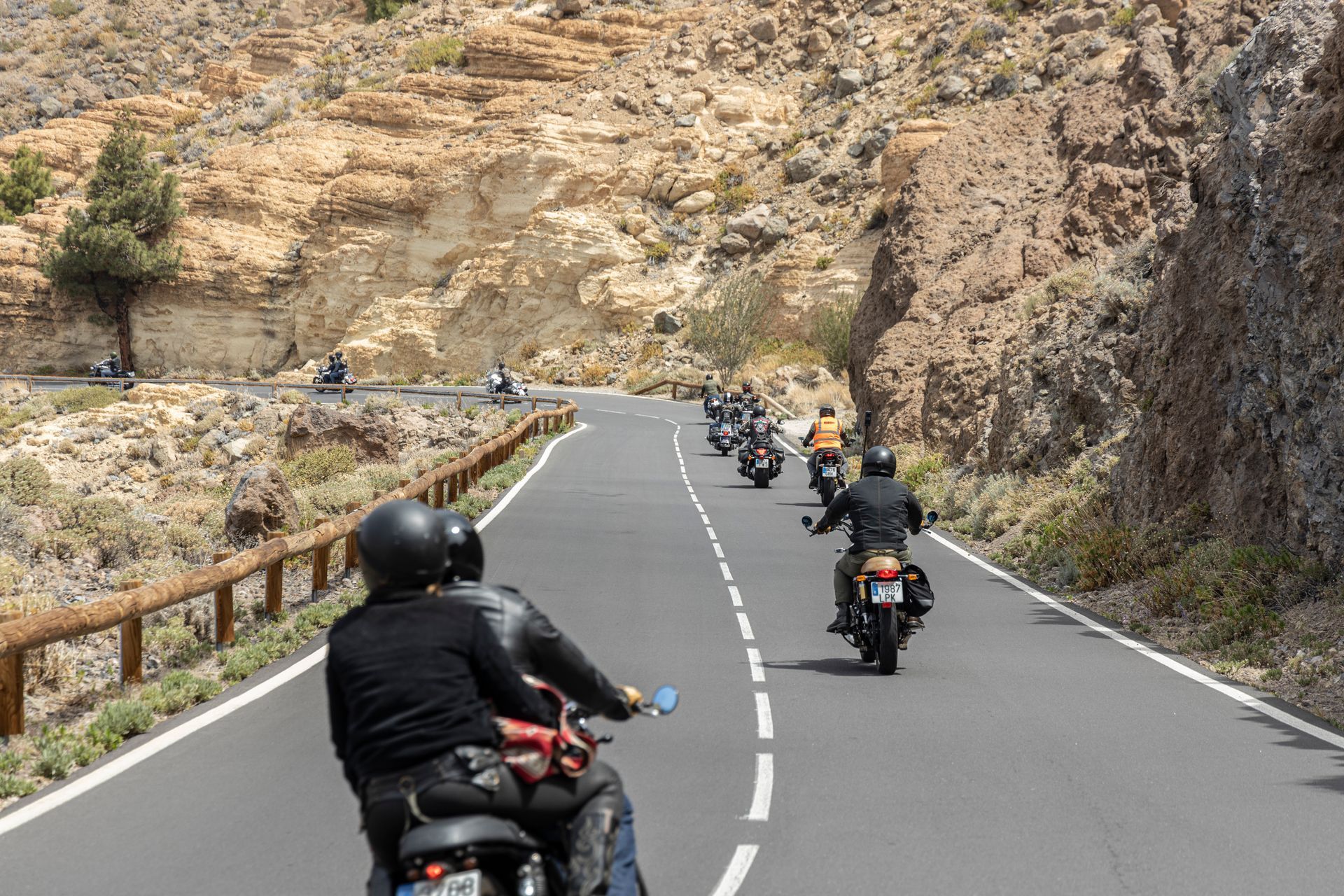 A group of people are riding motorcycles down a road.