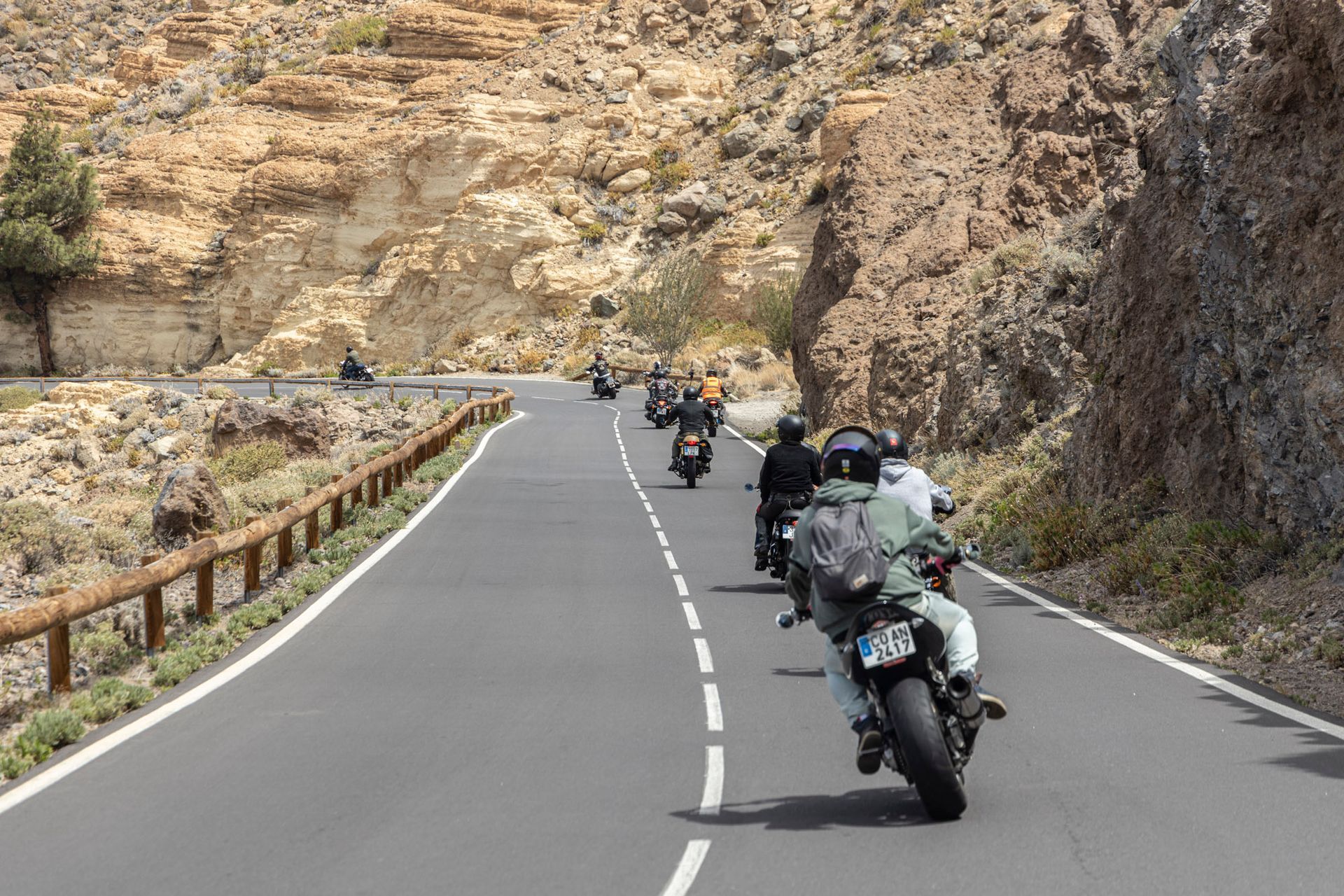 A group of people are riding motorcycles down a road.
