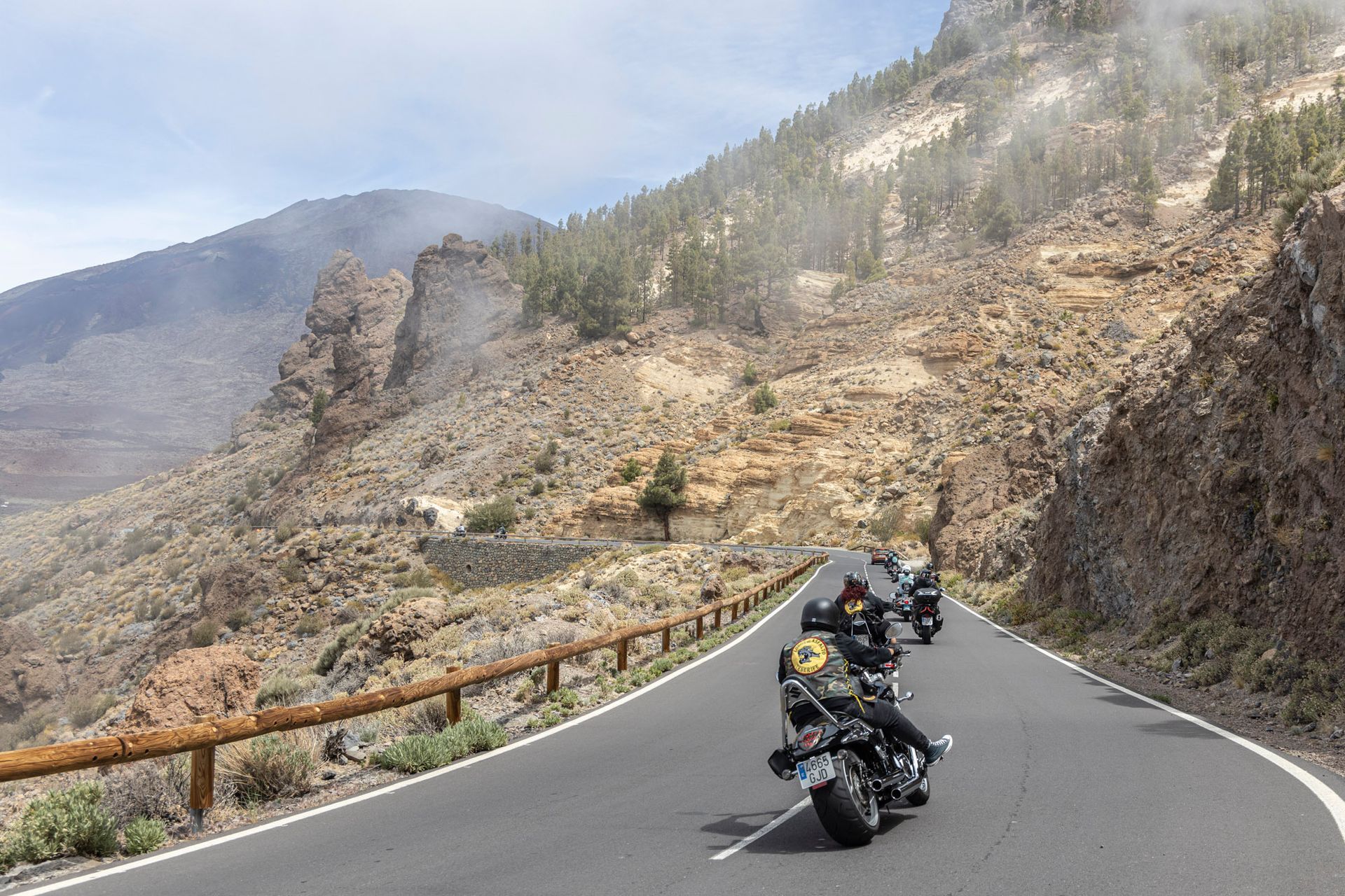 A person is riding a motorcycle down a mountain road
