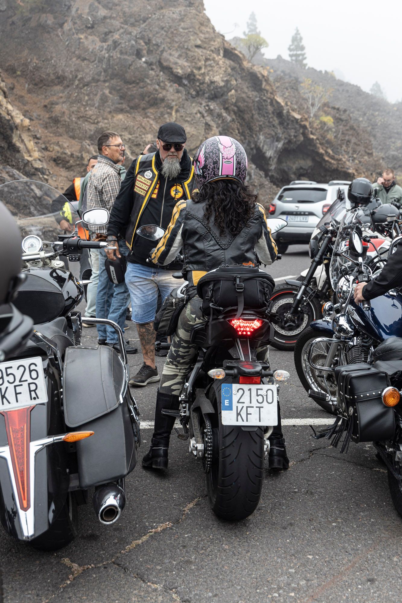 A group of people are riding motorcycles on a road.