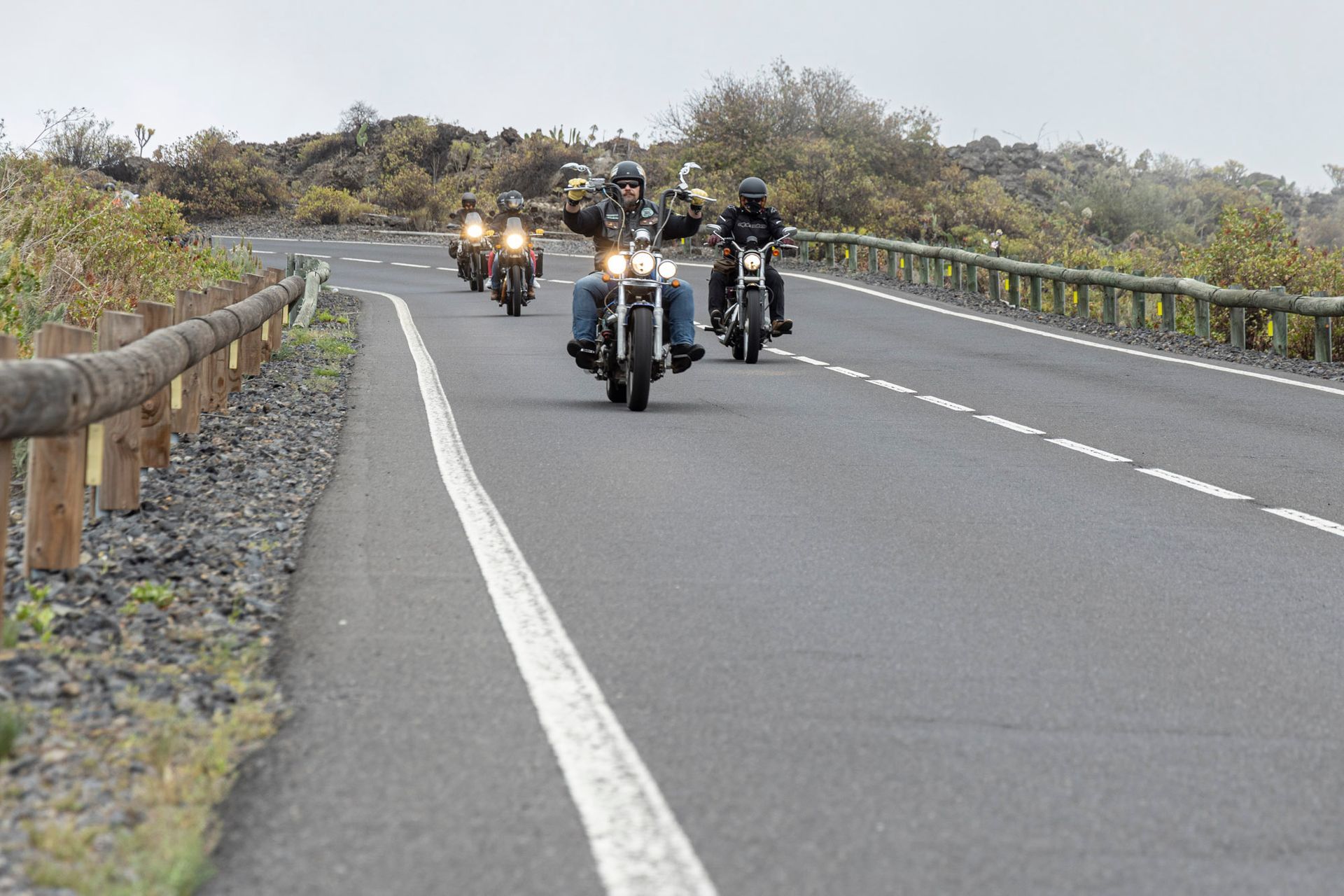 A group of people are riding motorcycles down a road.