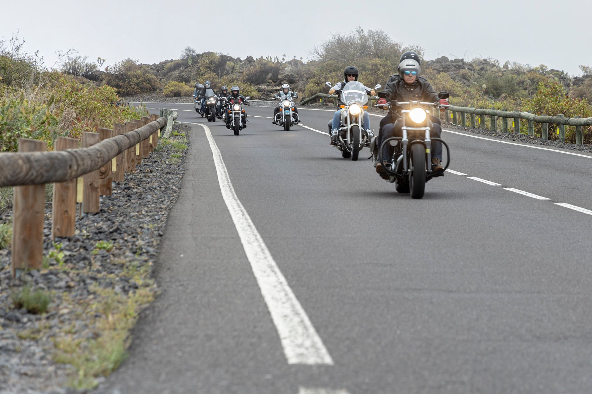 A group of people are riding motorcycles down a road.
