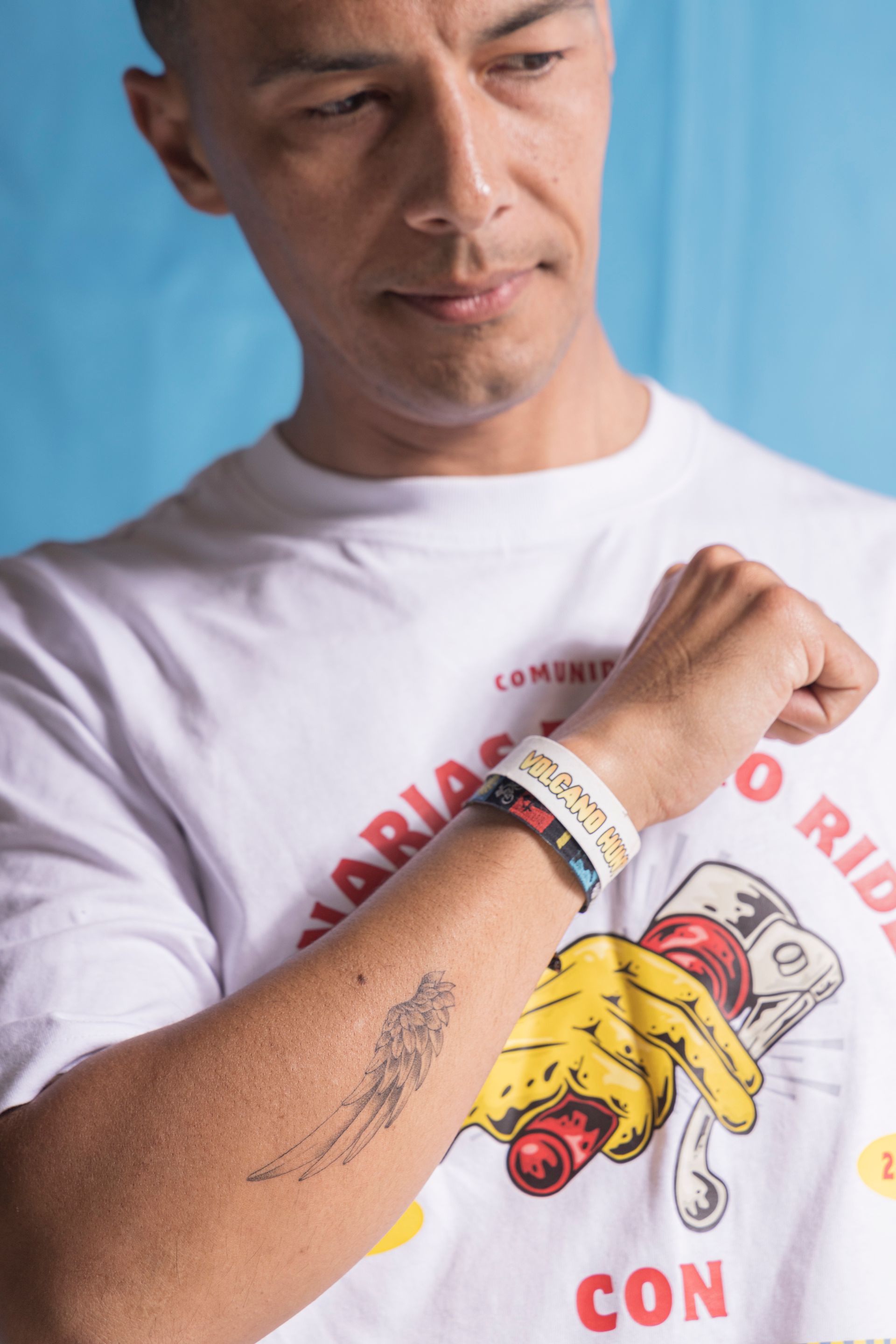 A man with a tattoo on his arm is wearing a white shirt