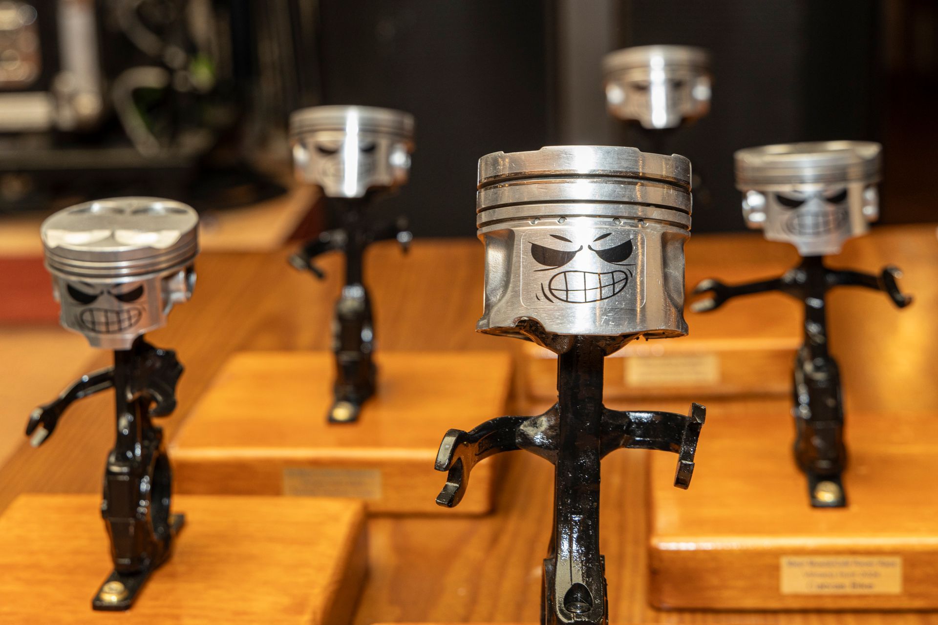 A group of pistons with skulls on them are sitting on a wooden table.