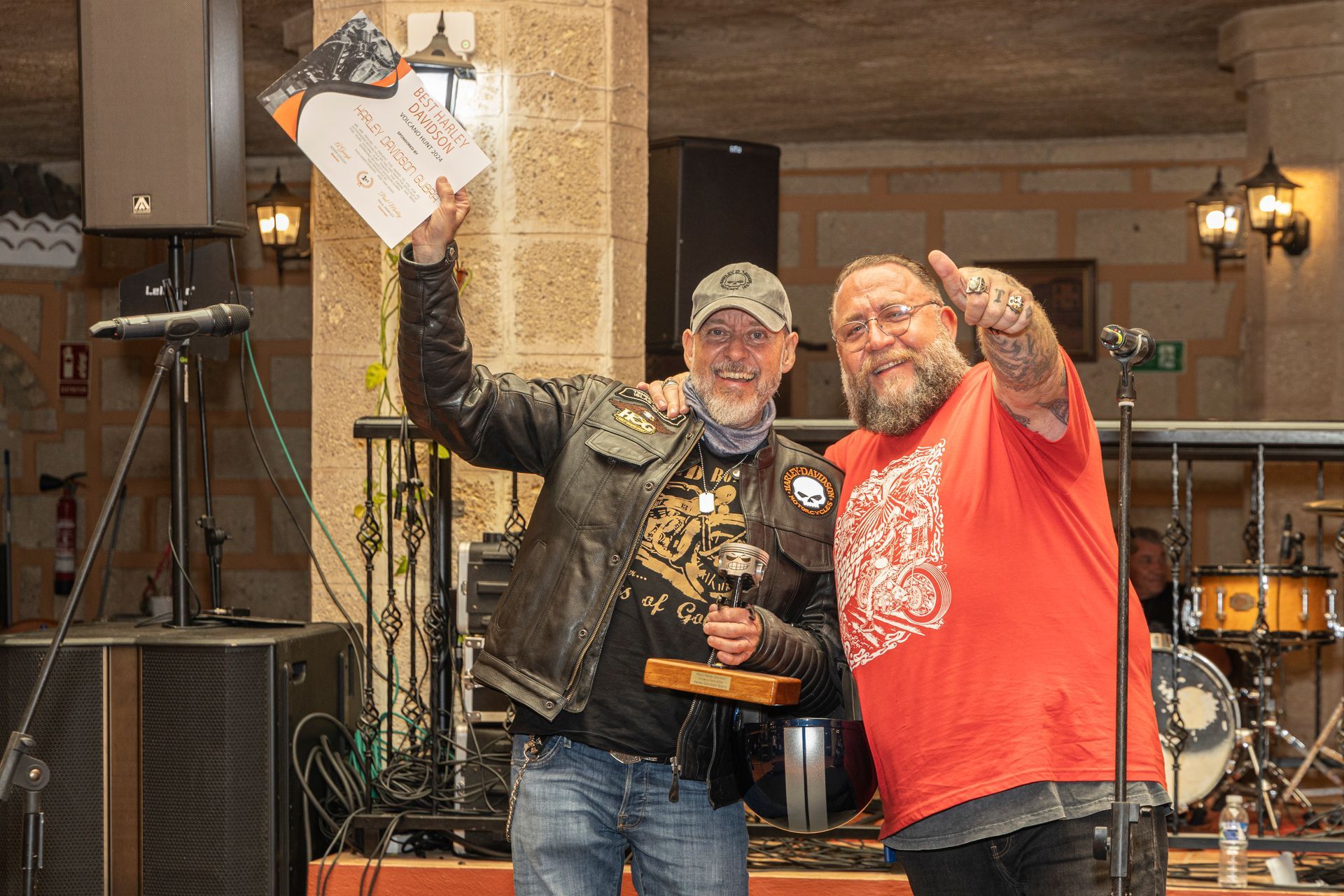 Two men are standing next to each other and one is holding a trophy.