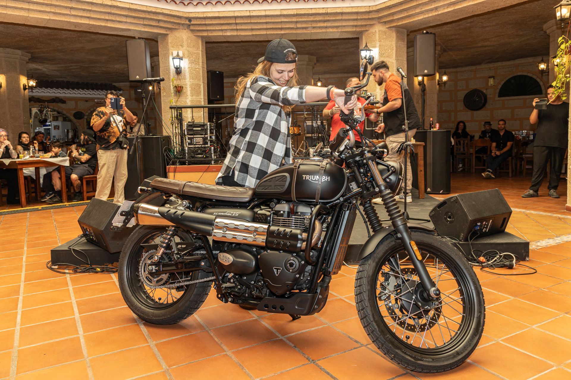 A man is riding a motorcycle on a tiled floor in a room.