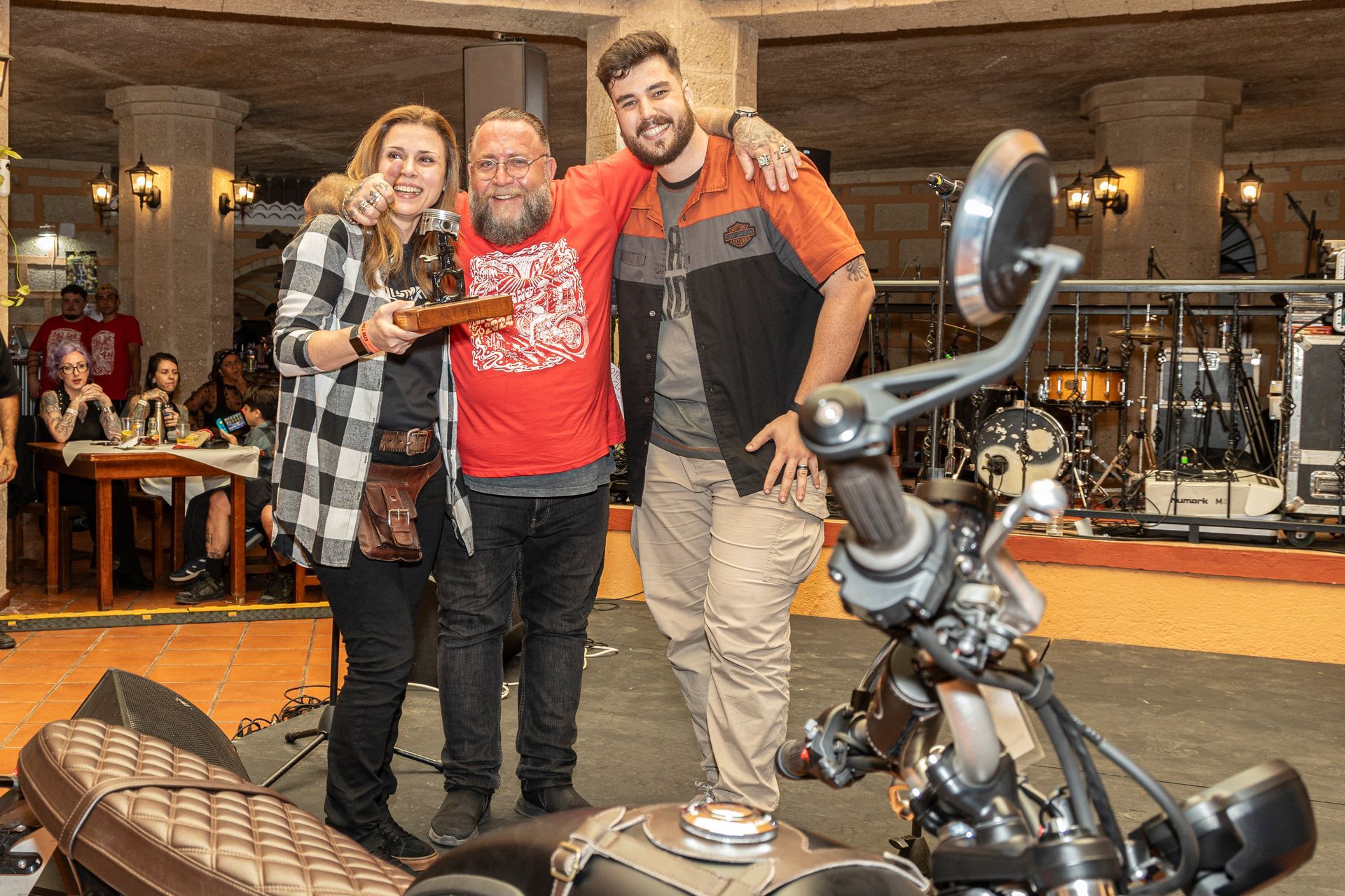 A group of people are posing for a picture in front of a motorcycle.