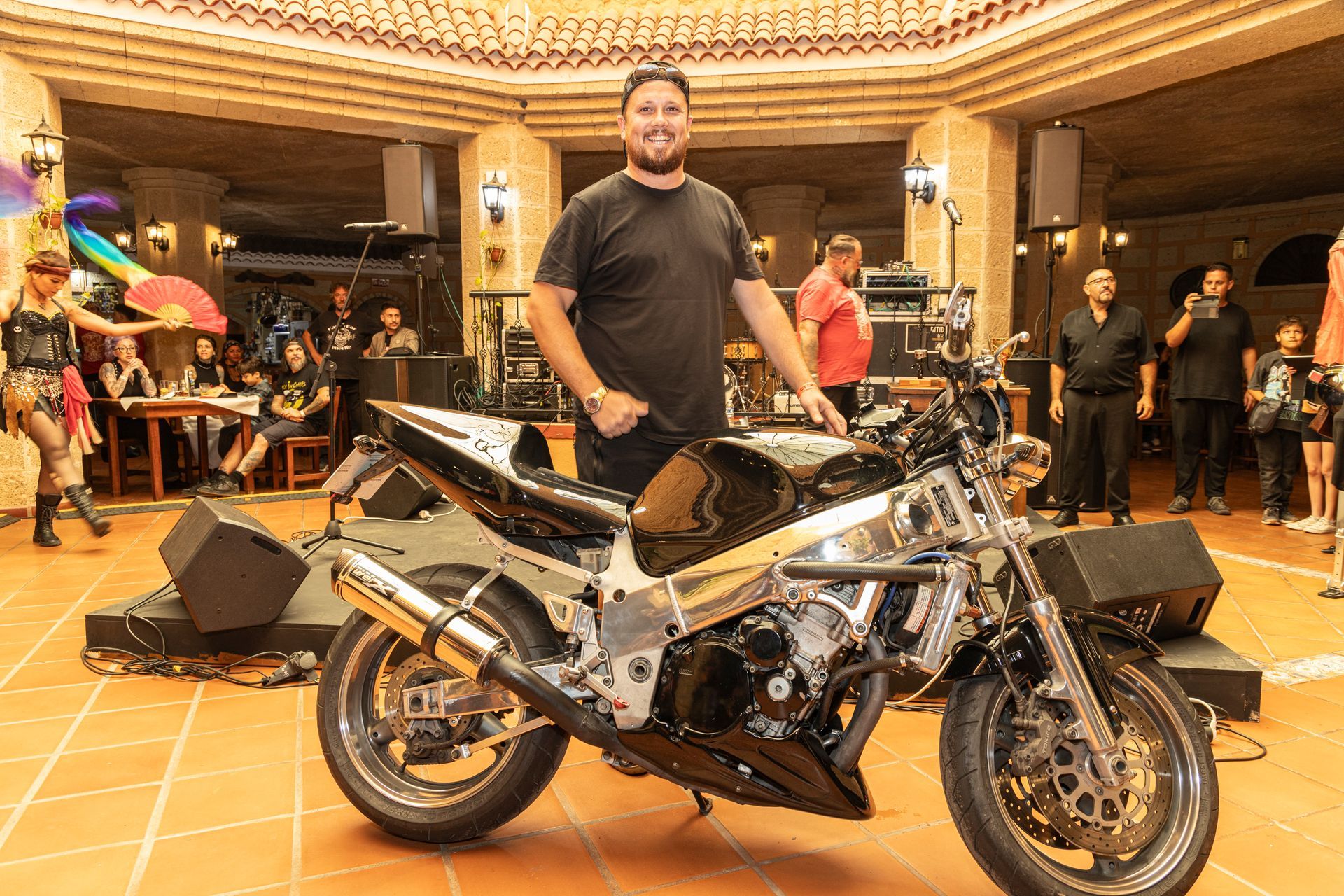 A man is standing next to a motorcycle in a room.