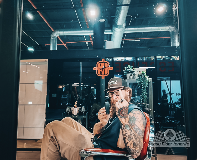 A man with a lot of tattoos is sitting in a barber chair