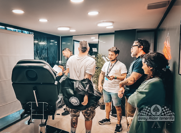 A group of people are standing around a chair in a room.
