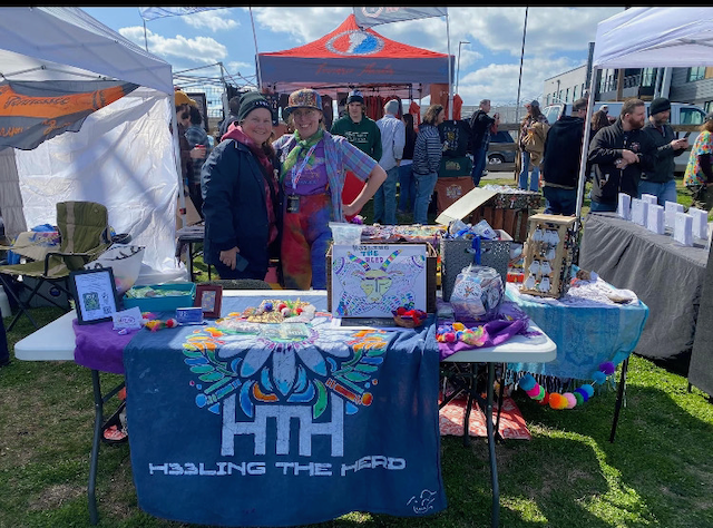 A group of people are standing around a table at a festival.