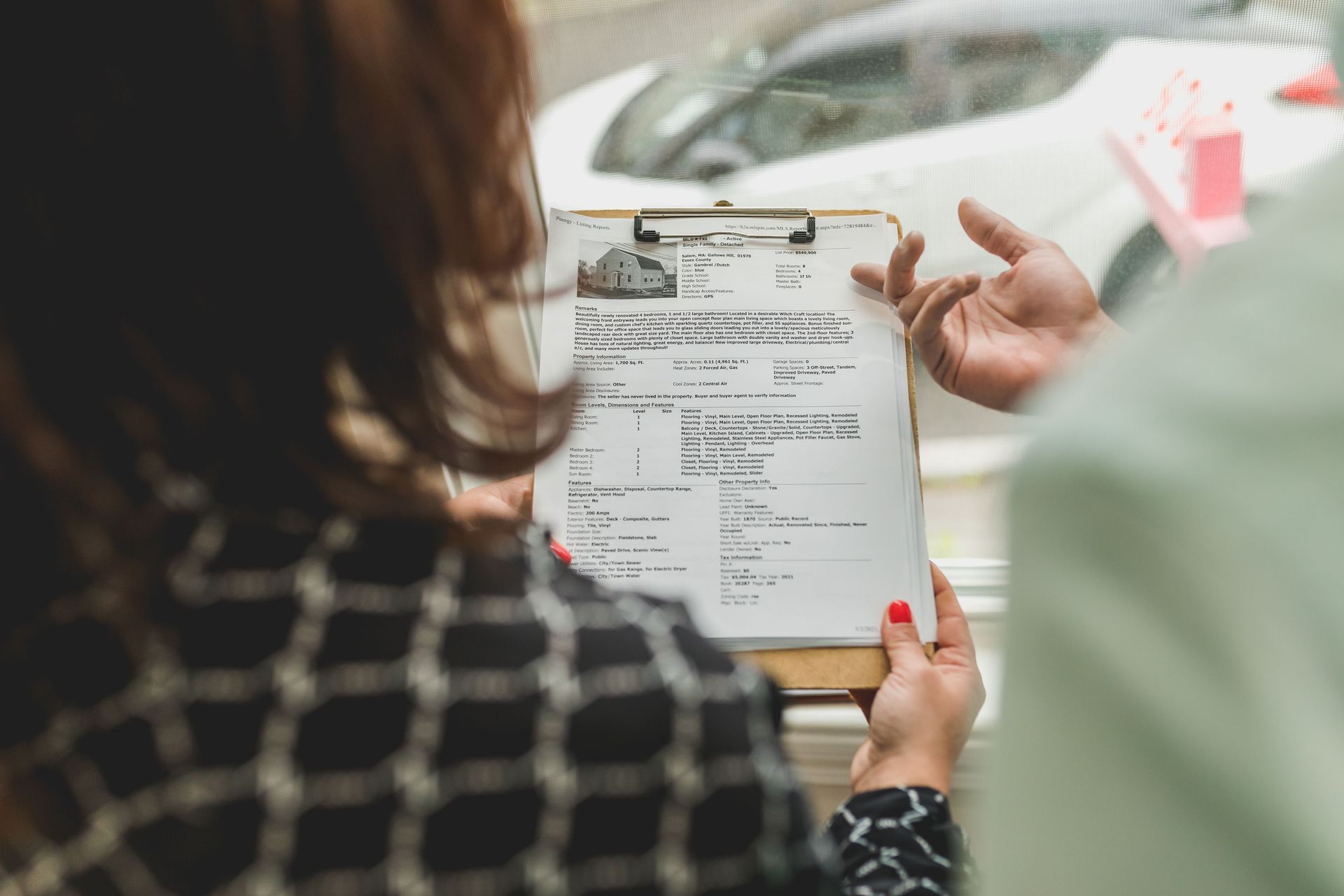 Person holding a clipboard with forms during a meeting at a table