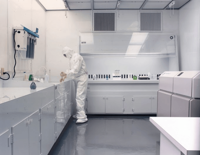 A person wearing a protective suit is working in a clean room