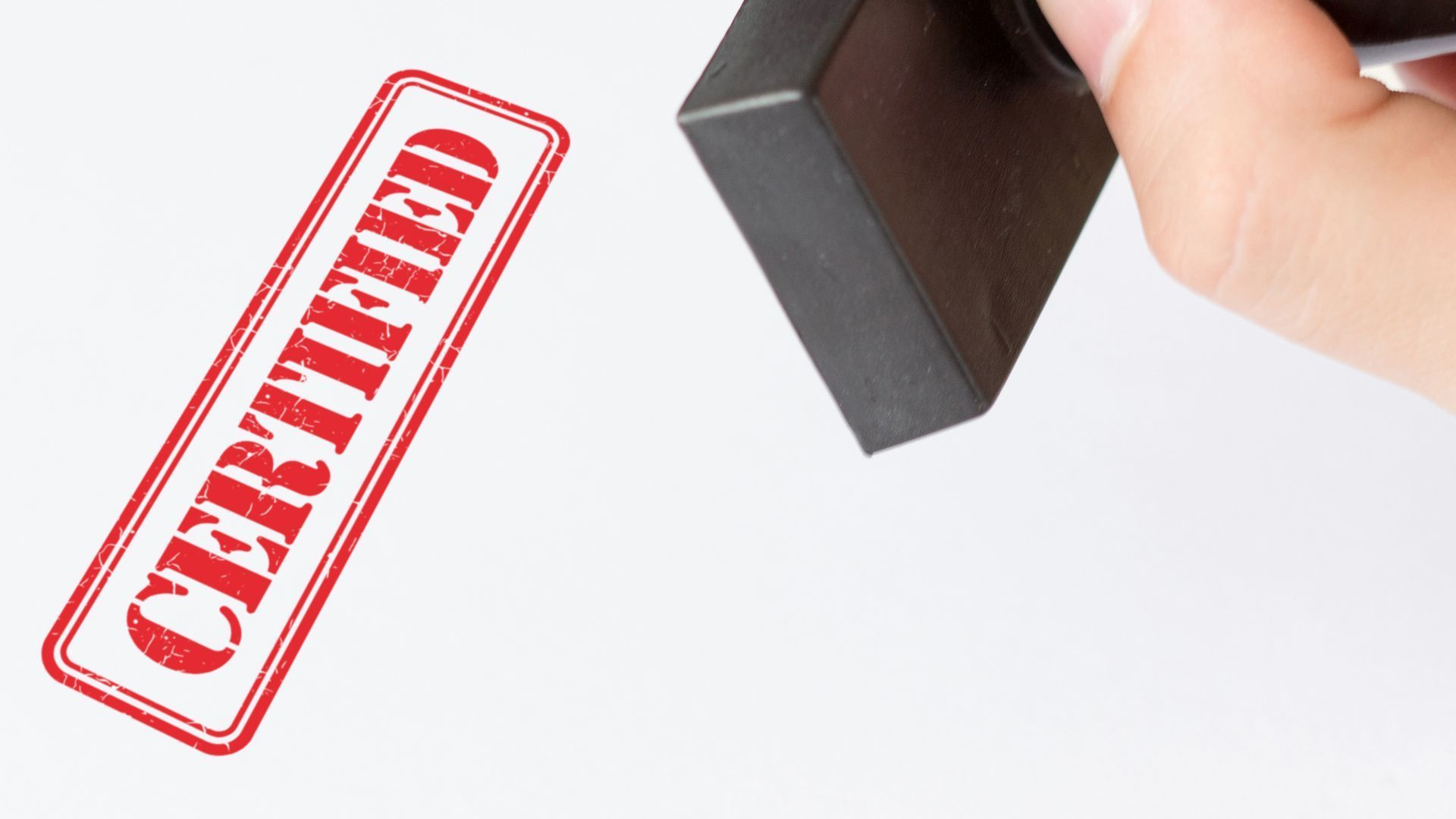 Stamp stamping a white page with a red certified stamp