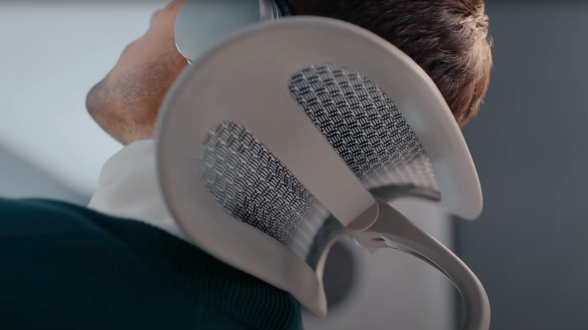 Close up of the back of a man's head resting on a grey mesh office chair's headrest. It's a great chair for creative work.