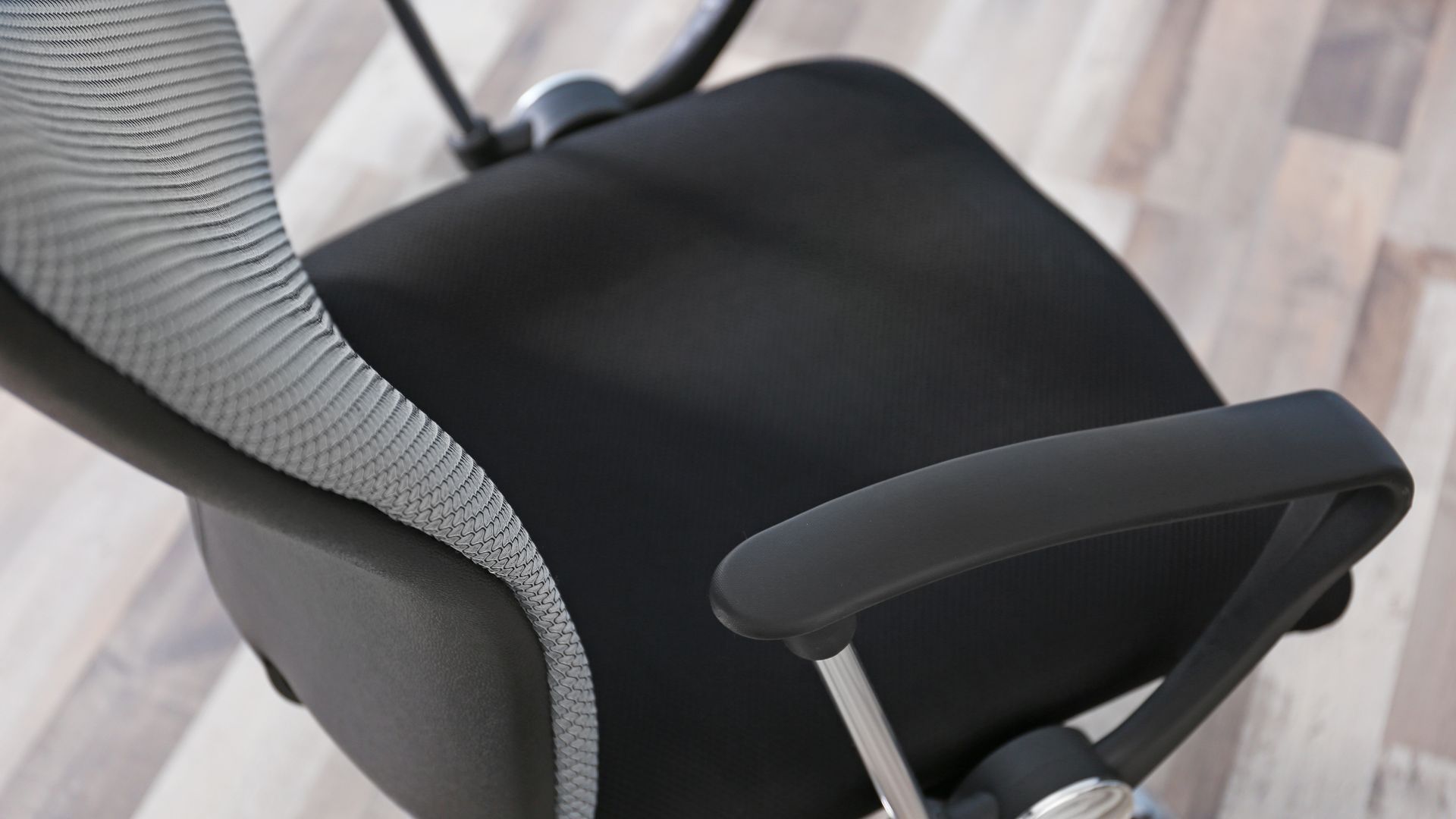 Black fabric chair facing from the top of the chair's back and tilting down