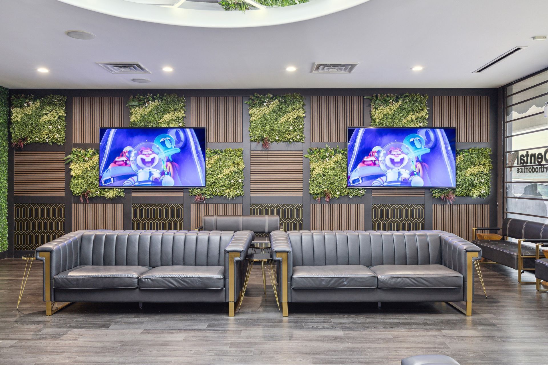 Aqua Dental and Orthodontics in Duncanville, TX. A waiting room with a couch and two televisions on the wall.